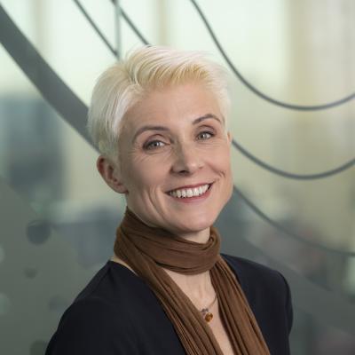 A photograph of Doris Ruth Eikhof, she has has short blonde hair and is wearing a brown scarf.