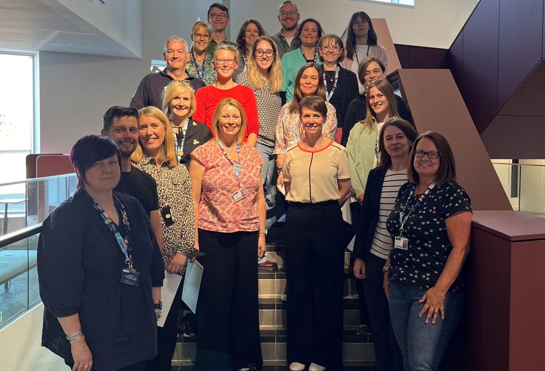 Group of participants from LMJU standing in a group on a set of stairs 