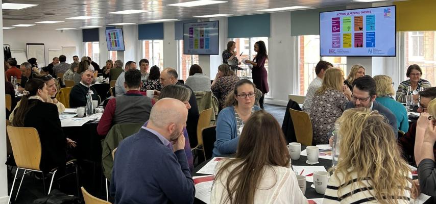 Members of the NCIA action learning groups discussing topics around tables.
