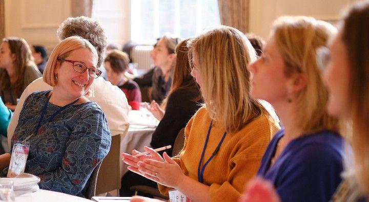 people at an event laughing and talking around a table