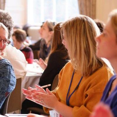 people at an event laughing and talking around a table