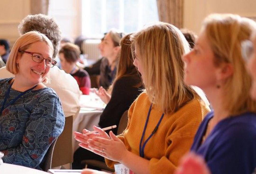 people at an event laughing and talking around a table
