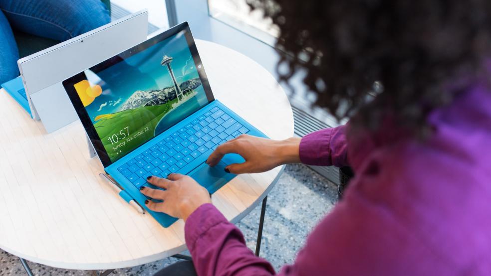 woman in purple jumper on blue laptop