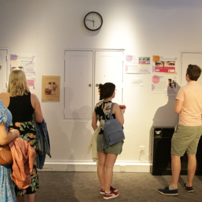 A group of people looking at display boards and posters on a wall